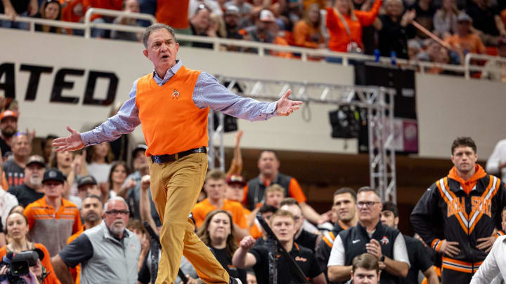 Feb 25, 2024; Stillwater, Okla, USA; Oklahoma State coach John Smith reacts on the mat at a