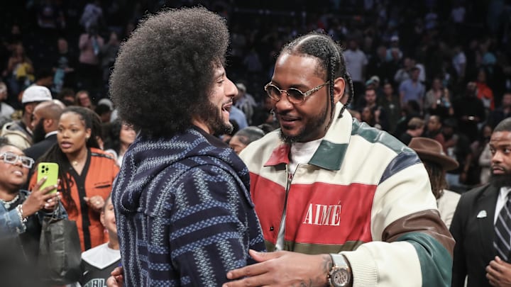 Oct 1, 2024; Brooklyn, New York, USA; Former NFL quarterback Colin Kaepernick embraces former NBA forward Carmelo Anthony after game two of the 2024 WNBA Semi-finals between the Las Vegas Aces and the New York Liberty at Barclays Center. Mandatory Credit: Wendell Cruz-Imagn Images