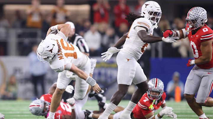 Jan 10, 2025; Arlington, Texas, USA; Texas Longhorns quarterback Arch Manning (16) runs against Ohio State Buckeyes cornerback Jordan Hancock (7) and safety Caleb Downs (2) during the second quarter of the College Football Playoff semifinal in the Cotton Bowl at AT&T Stadium. Mandatory Credit: Tim Heitman-Imagn Images