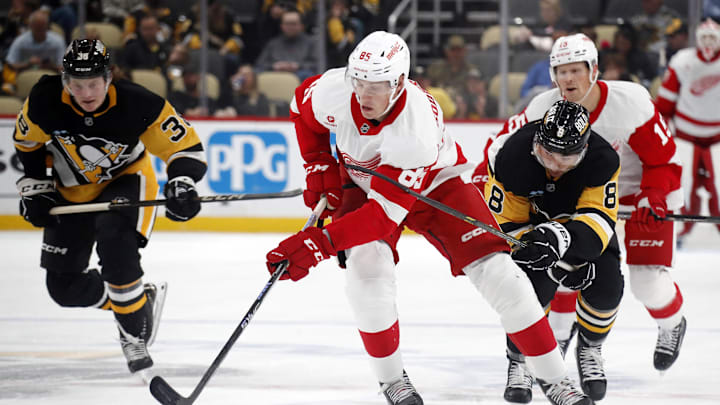 Oct 1, 2024; Pittsburgh, Pennsylvania, USA;  Detroit Red Wings left wing Elmer Soderblom (85) skates up ice with the puck ahead of Pittsburgh Penguins left wing Michael Bunting (8) during the second period at PPG Paints Arena. Mandatory Credit: Charles LeClaire-Imagn Images