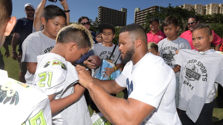 Aug 16 2019; Honolulu, HI, USA; Los Angeles Rams defensive end Aaron Donald signs autographs for youngsters at Cooke Field on the campus of the University of Hawaii. Mandatory Credit: Kirby Lee-Imagn Images