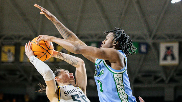 Feb 23, 2025; Wichita, Kansas, USA; Wichita State Shockers guard Bijan Cortes (55) shoots the ball around Tulane Green Wave guard Kam Williams (3) during the second half at Charles Koch Arena. Mandatory Credit: William Purnell-Imagn Images Feb 23, 2025; Wichita, Kansas, USA; Wichita State Shockers guard Bijan Cortes (55) shoots the ball around Tulane Green Wave guard Kam Williams (3) during the second half at Charles Koch Arena. Mandatory Credit: William Purnell-Imagn Images