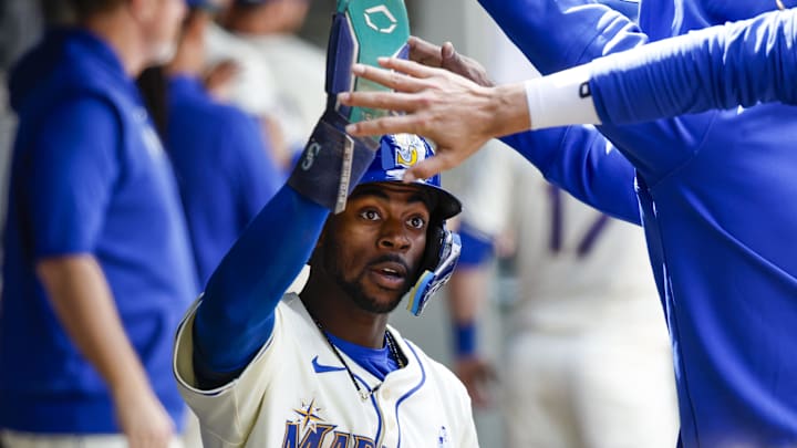 Seattle Mariners pinch runner Ryan Bliss (1) high-fives teammates in the dugout after scoring a run against the Texas Rangers during the eighth inning at T-Mobile Park. Seattle Mariners pinch runner Ryan Bliss (1) high-fives teammates in the dugout after scoring a run against the Texas Rangers during the eighth inning at T-Mobile Park.