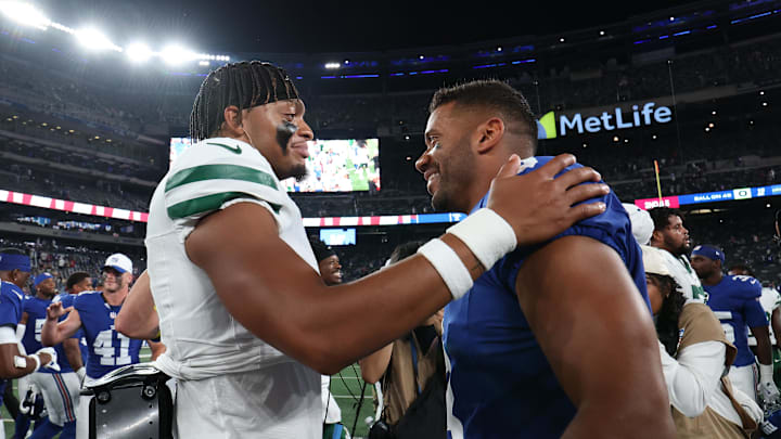 Aug 16, 2025; East Rutherford, New Jersey, USA; New York Jets quarterback Justin Fields (7) and New York Giants quarterback Russell Wilson (3) meet on the field after the preseason game at MetLife Stadium. Mandatory Credit: Vincent Carchietta-Imagn Images