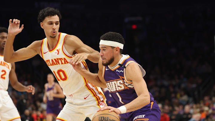 Jan 9, 2025; Phoenix, Arizona, USA; Phoenix Suns guard Devin Booker (1) against Atlanta Hawks forward Zaccharie Risacher (10) in the first half at Footprint Center. Mandatory Credit: Mark J. Rebilas-Imagn Images