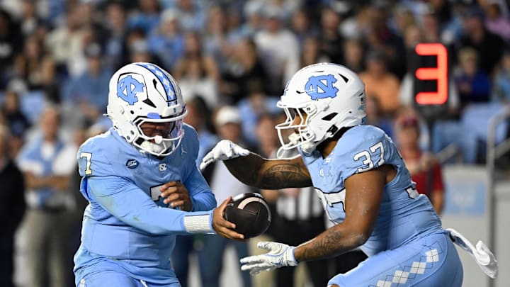 Nov 8, 2025; Chapel Hill, North Carolina, USA; North Carolina Tar Heels quarterback Gio Lopez (7) hands the ball off to running back Davion Gause (37) in the second quarter at Kenan Stadium. Mandatory Credit: Bob Donnan-Imagn Images