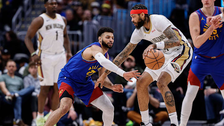 Jan 12, 2024; Denver, Colorado, USA; New Orleans Pelicans forward Brandon Ingram (14) controls the ball as Denver Nuggets guard Jamal Murray (27) defends in the third quarter at Ball Arena. Mandatory Credit: Isaiah J. Downing-Imagn Images