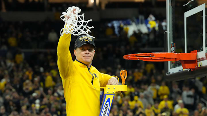 Apr 6, 2026; Indianapolis, IN, USA; Michigan Wolverines head coach Dusty May cuts down the net after defeating the Connecticut Huskies in the national championship of the Final Four of the men's 2026 NCAA Tournament at Lucas Oil Stadium. Mandatory Credit: Robert Deutsch-Imagn Images