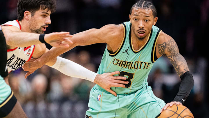 Jan 24, 2025; Charlotte, North Carolina, USA; Charlotte Hornets guard Nick Smith Jr. (8) drives against Portland Trail Blazers forward Deni Avdija (8) during the first quarter at Spectrum Center. Mandatory Credit: Scott Kinser-Imagn Images