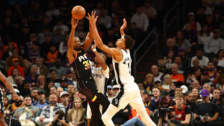 Dec 3, 2024; Phoenix, Arizona, USA; Phoenix Suns forward Kevin Durant (35) against San Antonio Spurs center Victor Wembanyama (1) in the first half of an NBA Cup game at Footprint Center. Mandatory Credit: Mark J. Rebilas-Imagn Images