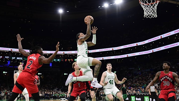 Oct 13, 2024; Boston, Massachusetts, USA;  Boston Celtics guard JD Davison (20) drives to the basket past Toronto Raptors forward Jonathan Mogbo (2) during the first half at TD Garden. Mandatory Credit: Bob DeChiara-Imagn Images