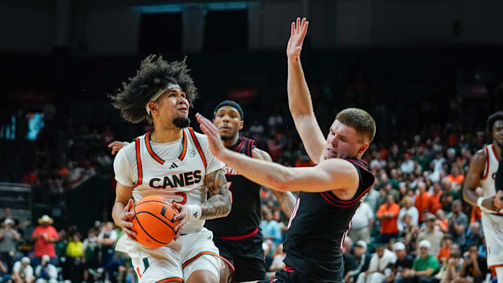 Mar 7, 2026; Coral Gables, Florida, USA; Miami Hurricanes guard Tre Donaldson (3) drives to the basket against Louisville Cardinals guard Isaac McKneely (10) during the second half at Watsco Center. Mandatory Credit: Jeff Romance-Imagn Images
