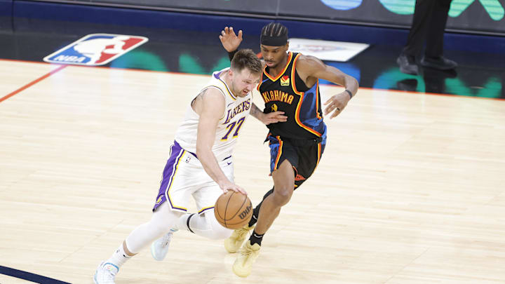 Apr 6, 2025; Oklahoma City, Oklahoma, USA; Los Angeles Lakers guard Luka Doncic (77) drives down the court beside Oklahoma City Thunder guard Shai Gilgeous-Alexander (2) during the second half at Paycom Center. Mandatory Credit: Alonzo Adams-Imagn Images