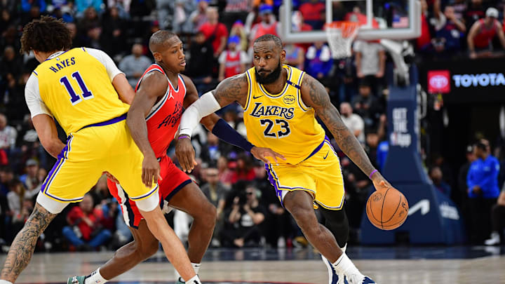Feb 4, 2025; Inglewood, California, USA; Los Angeles Lakers forward LeBron James (23) moves the ball as center Jaxson Hayes (11) provides coverage against Los Angeles Clippers guard Kris Dunn (8) during the second half at Intuit Dome. Mandatory Credit: Gary A. Vasquez-Imagn Images
