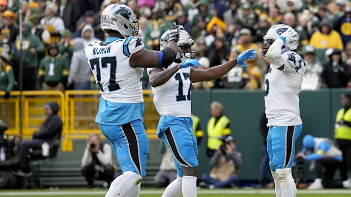 Nov 2, 2025; Green Bay, Wisconsin, USA; Carolina Panthers running back Rico Dowdle (5) celebrates with offensive tackle Yosh Nijman (77) and wide receiver Xavier Legette (17) after a touchdown during the second half against the Green Bay Packers at Lambeau Field. Mandatory Credit: Jeff Hanisch-Imagn Images
