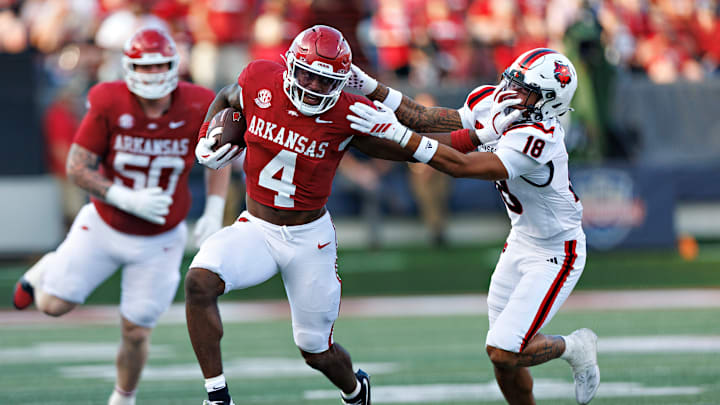 Arkansas Razorback senior tailback Mike Washington Jr. stiff arms Arkansas State safety Malekhi Weedon during Saturday's 56-14 Razorback win at War Memorial Stadium in Little Rock