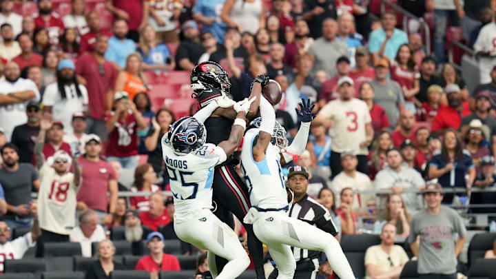 Arizona Cardinals receiver Marvin Harrison Jr. (18) makes a first-down catch over Tennessee Titans defenders Jalyn Armour-Davis (18) and Xavier Woods (25) at State Farm Stadium in Glendale on Oct. 5, 2025.