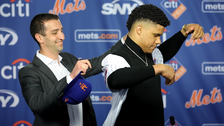Dec 12, 2024; Flushing, NY, USA; New York Mets general manager David Stearns puts a jersey on new right fielder Juan Soto during Soto's introductory press conference at Citi Field. Mandatory Credit: Brad Penner-Imagn Images