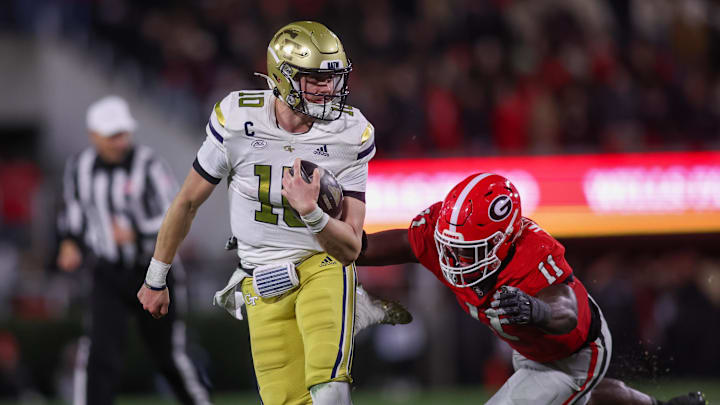 Nov 29, 2024; Athens, Georgia, USA; Georgia Tech Yellow Jackets quarterback Haynes King (10) runs the ball past Georgia Bulldogs linebacker Jalon Walker (11) in the second quarter at Sanford Stadium. Mandatory Credit: Brett Davis-Imagn Images