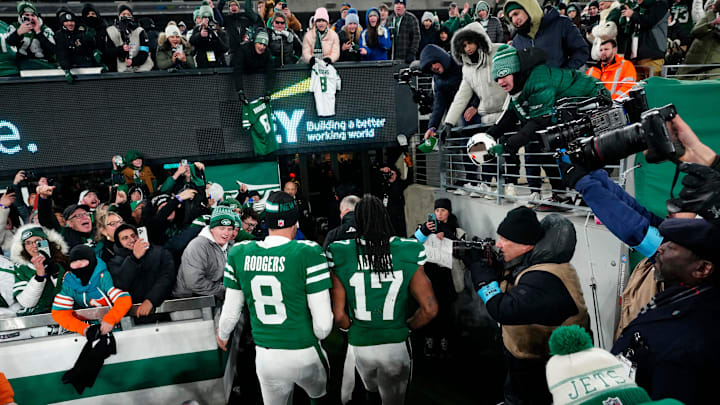 New York Jets quarterback Aaron Rodgers (8) and New York Jets wide receiver Davante Adams (17) step off the field to cheering fans, Sunday January 5, 2025, in East Rutherford.