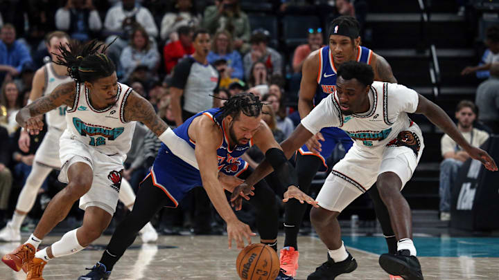 Feb 28, 2025; Memphis, Tennessee, USA; New York Knicks guard Jalen Brunson (middle), Memphis Grizzlies guard Ja Morant (12) and guard Vince Williams Jr. (5) battle for a loose ball during the fourth quarter at FedExForum. Mandatory Credit: Petre Thomas-Imagn Images