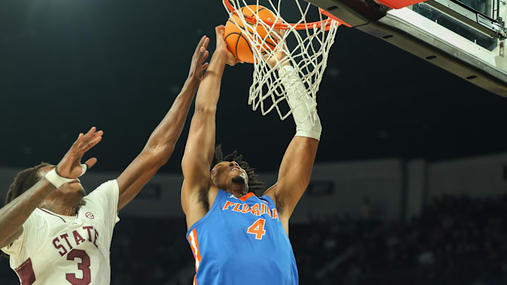 Feb 11, 2025; Starkville, Mississippi, USA; Florida Gators forward Sam Alexis (4) dunks the ball against Mississippi State Bulldogs forward KeShawn Murphy (3) during the first half at Humphrey Coliseum. Mandatory Credit: Wesley Hale-Imagn Images