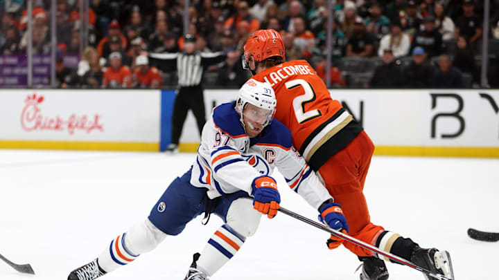Apr 24, 2026; Anaheim, California, USA;  Edmonton Oilers center Connor McDavid (97) fights for the puck against Anaheim Ducks defenseman Jackson LaCombe (2) during the third period of game three of the first round of the 2026 Stanley Cup Playoffs at Honda Center. Mandatory Credit: Kiyoshi Mio-Imagn Images