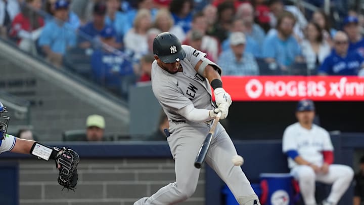 Jul 21, 2025; Toronto, Ontario, CAN; New York Yankees third baseman Oswald Peraza (18)  hits a single against the Toronto Blue Jays during the fifth inning at Rogers Centre. Mandatory Credit: Nick Turchiaro-Imagn Images