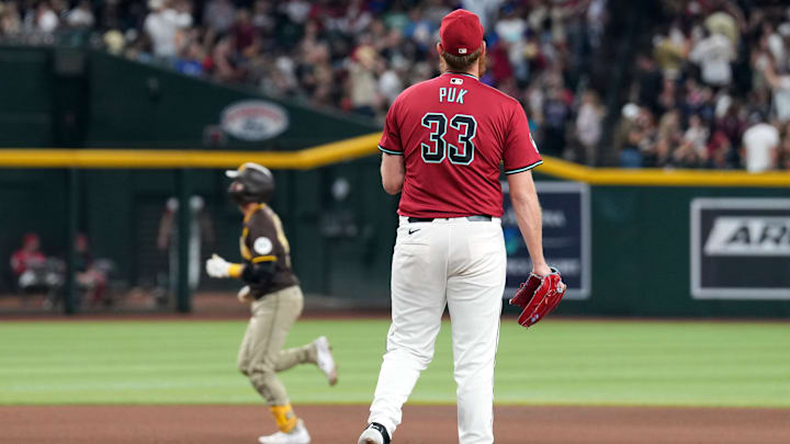Sep 28, 2024; Phoenix, Arizona, USA; Arizona Diamondbacks pitcher A.J. Puk (33) reacts after allowing a home run to San Diego Padres catcher Kyle Higashioka (20) during the ninth inning at Chase Field. Mandatory Credit: Joe Camporeale-Imagn Images