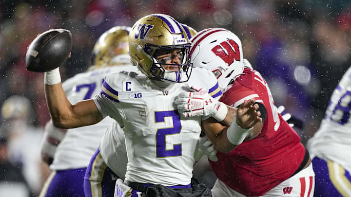 UW quarterback Demond Williams Jr. (2) throws the ball away under pressure from Wisconsin's Brandon Lane Jr. 