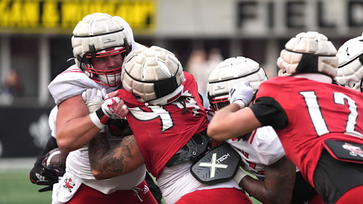 Red Louisville's Jordan Guerad lays into White Louisville's Pete Nygra to try and stop the run in the Spring Game Friday night at L&N Stadium