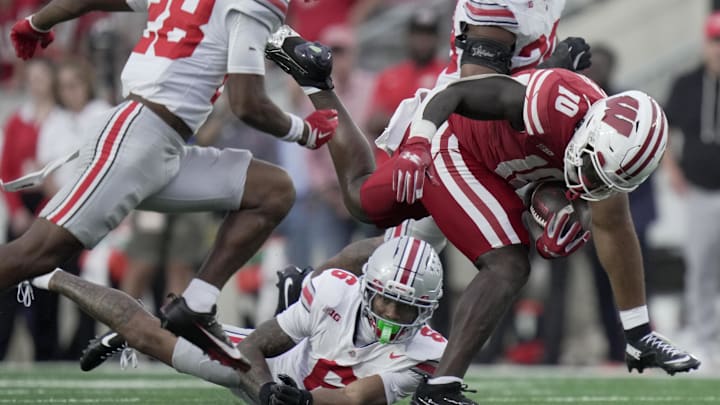 Oct 18, 2025; Madison, Wisconsin, USA;  Wisconsin running back Gideon Ituka (10) stumbles forward  during the fourth quarter of their game against Ohio State at Camp Randall Stadium. Mandatory Credit: Mark Hoffman-USA TODAY Network via Imagn Images