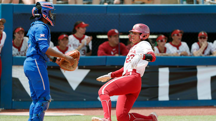 Oklahoma's Tiare Jennings (23) slides home to score a run past Kansas catcher Lyric Moore (3) in the quarterfinal round of the Big 12 Softball Championship in Oklahoma City on Thursday.