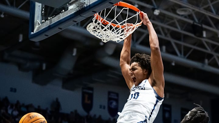North Florida Ospreys forward Josh Harris (10) slam dunks the ball in the first half over Jacksonville Dolphins forward Tito Deng (15). Jacksonville University played University of North Florida Thursday night, February 20, 2025 in the River City Rumble in Jacksonville, Fl. JU lead 35-34 over UNF at the half. [Doug Engle/Florida Times-Union]2025