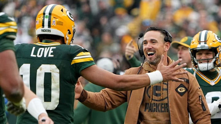Green Bay Packers quarterback Jordan Love (10) is hugged by head coach Matt LaFleur after throwing a