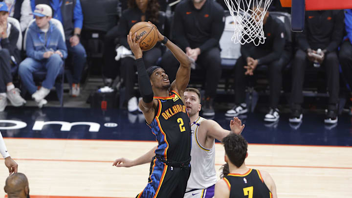 Apr 6, 2025; Oklahoma City, Oklahoma, USA; Oklahoma City Thunder guard Shai Gilgeous-Alexander (2) goes up for a basket beside Los Angeles Lakers guard Luka Doncic (77) during the first quarter at Paycom Center. Mandatory Credit: Alonzo Adams-Imagn Images