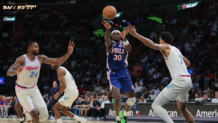 Apr 7, 2025; Miami, Florida, USA;  Philadelphia 76ers center Adem Bona (30) passes the basketball while driving to the basket against Miami Heat center Kel'el Ware (7) and forward Haywood Highsmith (24) during the third quarter at Kaseya Center. Mandatory Credit: Sam Navarro-Imagn Images