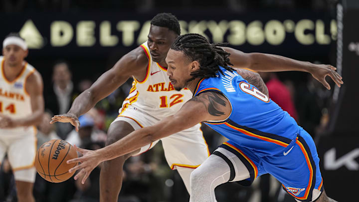 Oct 25, 2025; Atlanta, Georgia, USA; Atlanta Hawks center N'Faly Dante (12) and Oklahoma City Thunder forward Jaylin Williams (6) battle to control a loose ball during the first half at State Farm Arena. Mandatory Credit: Dale Zanine-Imagn Images