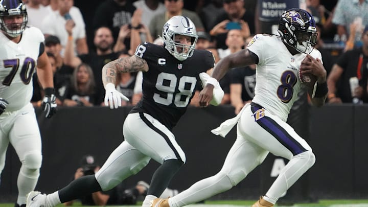 Sep 13, 2021; Paradise, Nevada, USA; Baltimore Ravens quarterback Lamar Jackson (8) runs the ball ahead of Las Vegas Raiders defensive end Maxx Crosby (98) during the first half at Allegiant Stadium. Mandatory Credit: Kirby Lee-Imagn Images