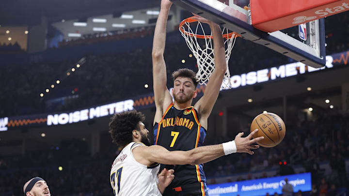 Mar 9, 2025; Oklahoma City, Oklahoma, USA; Denver Nuggets guard Jamal Murray (27) passes around Oklahoma City Thunder forward Chet Holmgren (7) during the second quarter at Paycom Center. Mandatory Credit: Alonzo Adams-Imagn Images