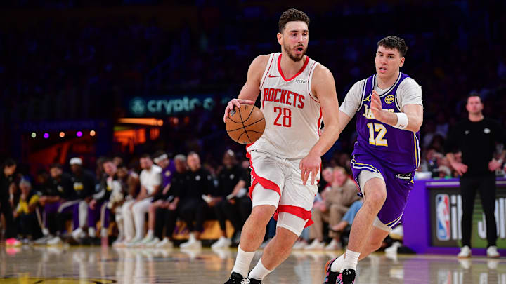 Apr 29, 2026; Los Angeles, California, USA; Houston Rockets center Alperen Sengun (28) moves the ball against Los Angeles Lakers forward Jake LaRavia (12) during the second half in game five of the first round of the 2026 NBA Playoffs at Crypto.com Arena. Mandatory Credit: Gary A. Vasquez-Imagn Images