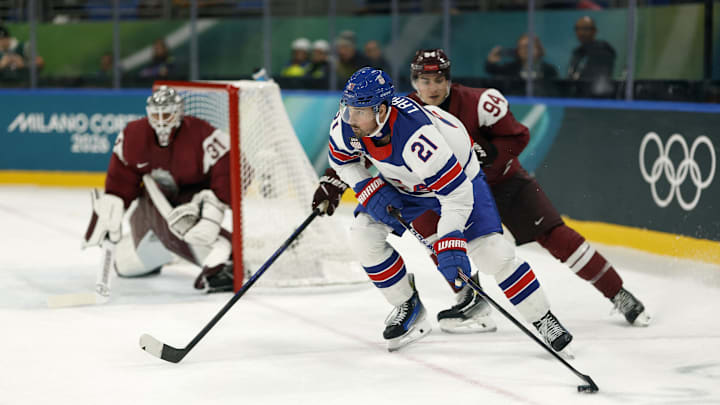 Feb 12, 2026; Milan, Italy;  Dylan Larkin of United States in action with Kristians Rubins of Latvia in men's ice hockey group C play during the Milano Cortina 2026 Olympic Winter Games at Milano Santagiulia Ice Hockey Arena. Mandatory Credit: Geoff Burke-Imagn Images