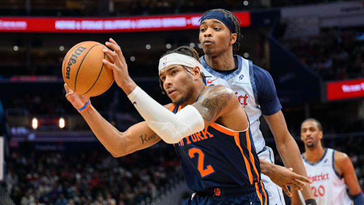 Dec 30, 2024; Washington, District of Columbia, USA; New York Knicks guard Miles McBride (2) grabs a rebound over Washington Wizards guard Bilal Coulibaly (0) during the third quarter at Capital One Arena. Mandatory Credit: Reggie Hildred-Imagn Images