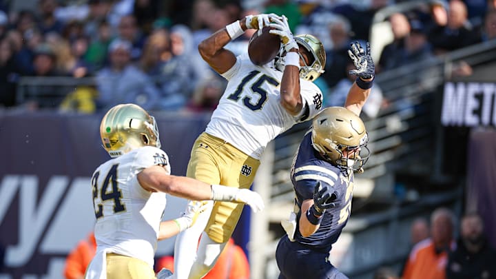 Oct 26, 2024; East Rutherford, New Jersey, USA; Notre Dame Fighting Irish cornerback Leonard Moore (15) intercepts a pass intended for Navy Midshipmen running back Eli Heidenreich (22) in front of linebacker Jack Kiser (24) during the second half at MetLife Stadium. Oct 26, 2024; East Rutherford, New Jersey, USA; Notre Dame Fighting Irish cornerback Leonard Moore (15) intercepts a pass intended for Navy Midshipmen running back Eli Heidenreich (22) in front of linebacker Jack Kiser (24) during the second half at MetLife Stadium.