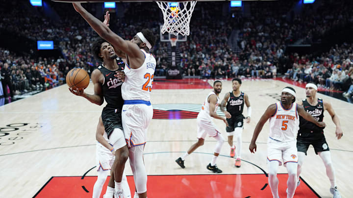 Mar 12, 2025; Portland, Oregon, USA; Portland Trail Blazers guard Scoot Henderson (00, left) shoots the ball against New York Knicks center Mitchell Robinson (23) during the first half at Moda Center. Mandatory Credit: Soobum Im-Imagn Images