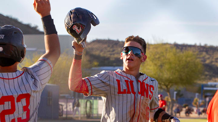 Liberty's Derek Kiepke (23) high-fives teammate Braden Watson (6) as he comes into the dugout at Sandra Day O'Connor High School baseball field in Phoenix on March 29, 2024.