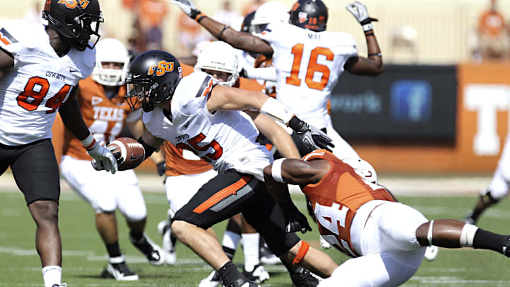 Oklahoma State Cowboys wide receiver Josh Cooper (25) evades the tackle of Texas Longhorns defensive back Sam Walker (24) during the first half against the Texas Longhorns at Royal-Texas Memorial Stadium. He was hired to be the head coach of Hinton, Oklahoma, ahead of the 2025 season.