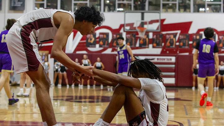 Kaden House (10) helps up teammate Javon Bardwell (24) at Desert Mountain High School gym in Scottsdale on Jan. 24, 2024.