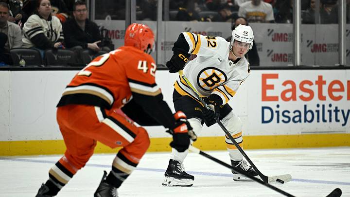 Oct 16, 2026; Anaheim, California, USA;  Boston Bruins defenseman Frederic Brunet (42) skates with the puck against Anaheim Ducks center Tim Washe (42) during the second period at Honda Center.  Mandatory Credit: Griffin Hooper-Imagn Images
