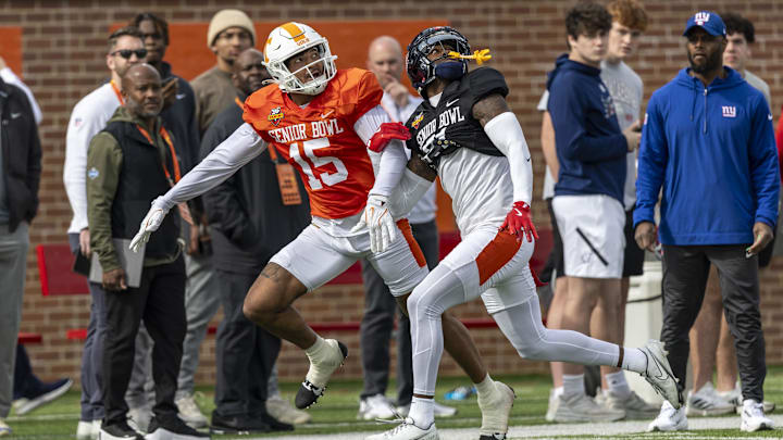 American team wide receiver Bru McCoy III of Tennessee (15) battles with American team defensive back Trey Amos of Ole Miss (21) during Senior Bowl practice.